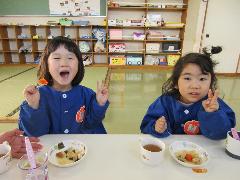 写真：おでんの入った皿を前に、2人の年少児が笑顔でピースサインをしています。