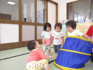 写真：保育室でファニートンネルを使い、出たり入ったりして遊んでいるひよこ組の子どもたち