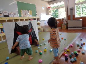 写真：園児が鬼ヶ島の絵に向かって新聞玉を投げています。