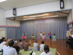 写真：おじいちゃんとおばあちゃんの前で、4・5歳児が曲に合わせ、遊戯を発表しています