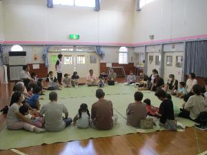 写真：おじいちゃんおばあちゃんと円になって座り、ゲームをしているところです