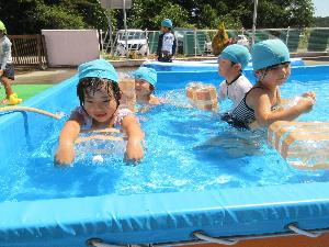 写真：空のペットボトルを浮き代わりにして、泳ぐ練習をしている4歳児たち