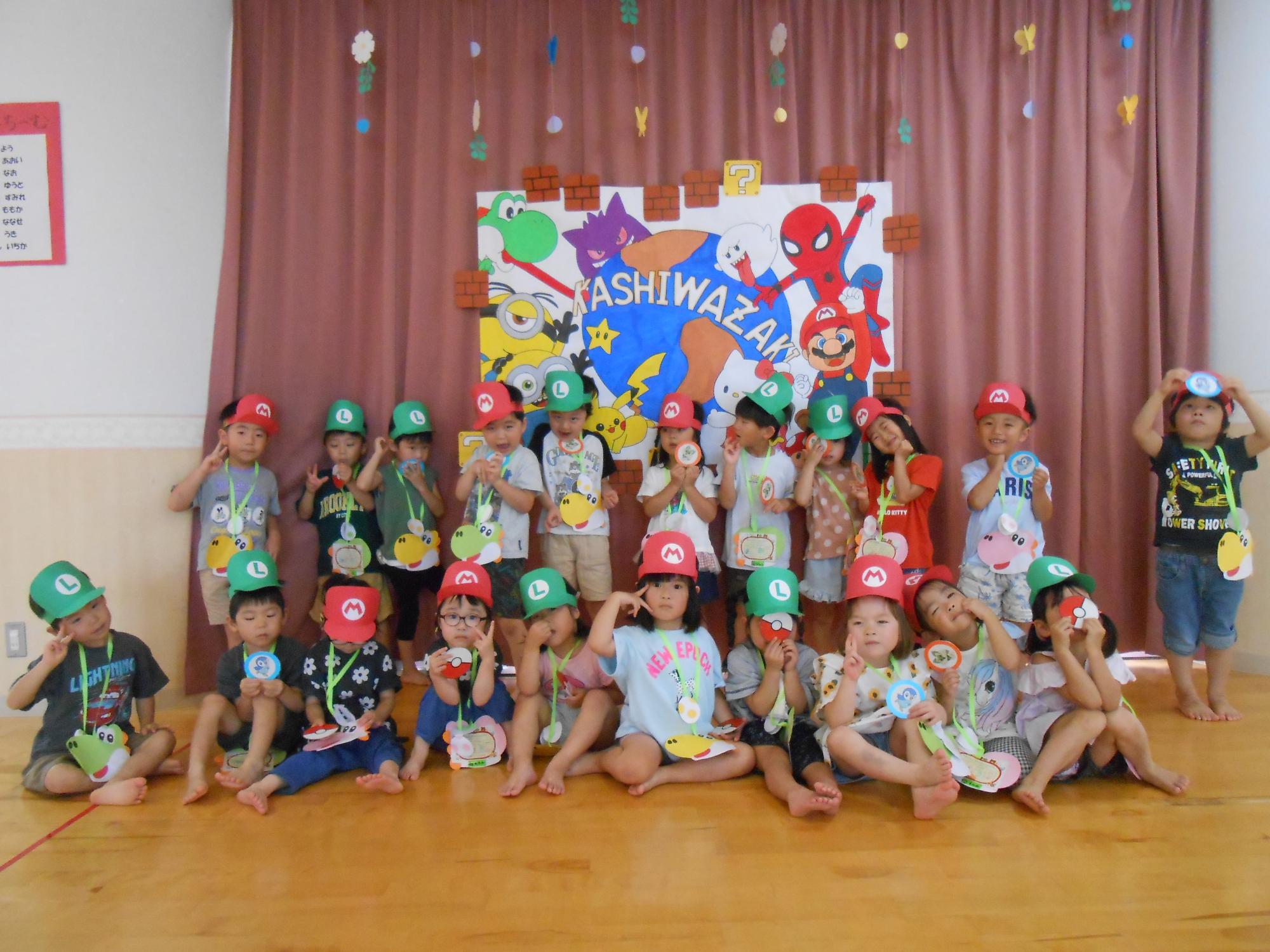 写真：ユニバーサルスタジオのキャラクターが描いてある看板の前でポーズをとる4歳児の子どもたち