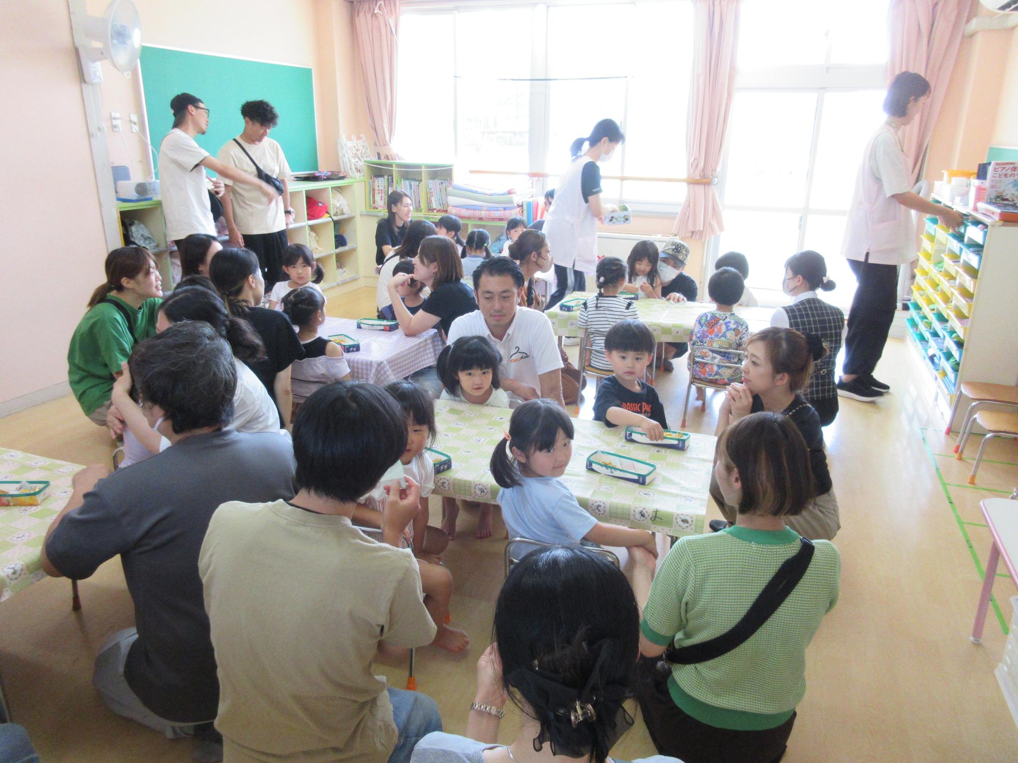 写真：子どもたちの横や後ろに保護者が座り、そわそわ嬉しそうな様子の4歳児。この後、花火制作を行いました。