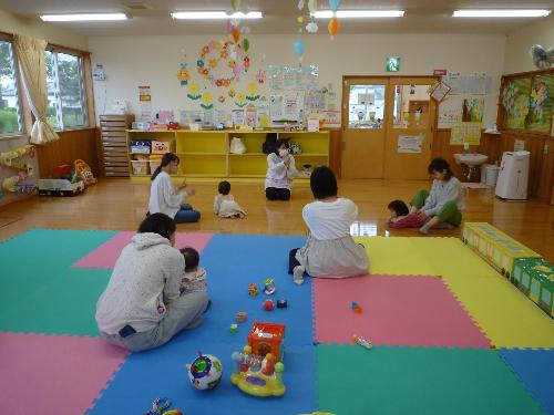 写真：お日様ルームの保育士と手遊びを楽しむ4組の親子