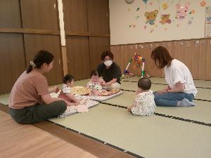 写真：支援室に遊びにきた3組の保護者が、お子さんを隣で遊ばせながら和やかに話をしています。