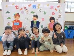 写真：うさぎ組の子どもたちが、七五三のお祝いの絵をバックにして並んでいます