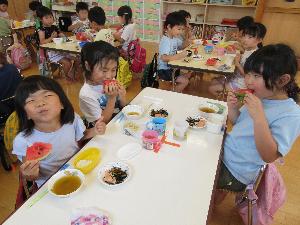 写真：自分たちで育てたスイカをおいしそうに食べるぞう組の子どもたち