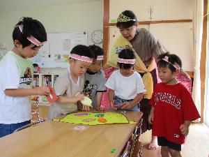 写真：異年齢の子どもたちがチームになって、宝の地図を見ながらゲームに取り組んでいます