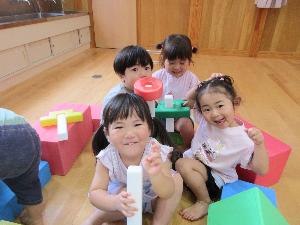 写真：積み木で周りを囲み、お家ごっこを楽しむ子どもたち