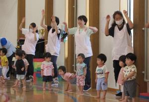 写真：1・2歳児が職員と一緒に、ジャンボリーミッキーの曲に合わせて踊っているところ