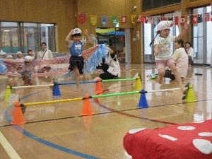 写真：4歳児2人が笑顔でミニハードルを飛び越えている様子