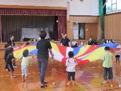 写真：子どもたちと保育者がバルーンの演技を披露しているところ