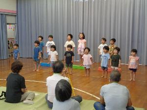 写真：園児がステージに並んで歌を披露しています。