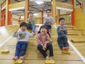 写真：キッズマジックの木のアスレチックの坂に座り、記念撮影する5人の子どもたち