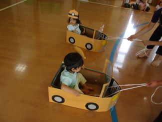 写真：りす組の子どもたちがジープ車を模した段ボールの中に入り、引っ張ってもらっています。