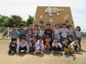 写真：ぞう組18人が園庭の遊具の前で写真を撮っているところ