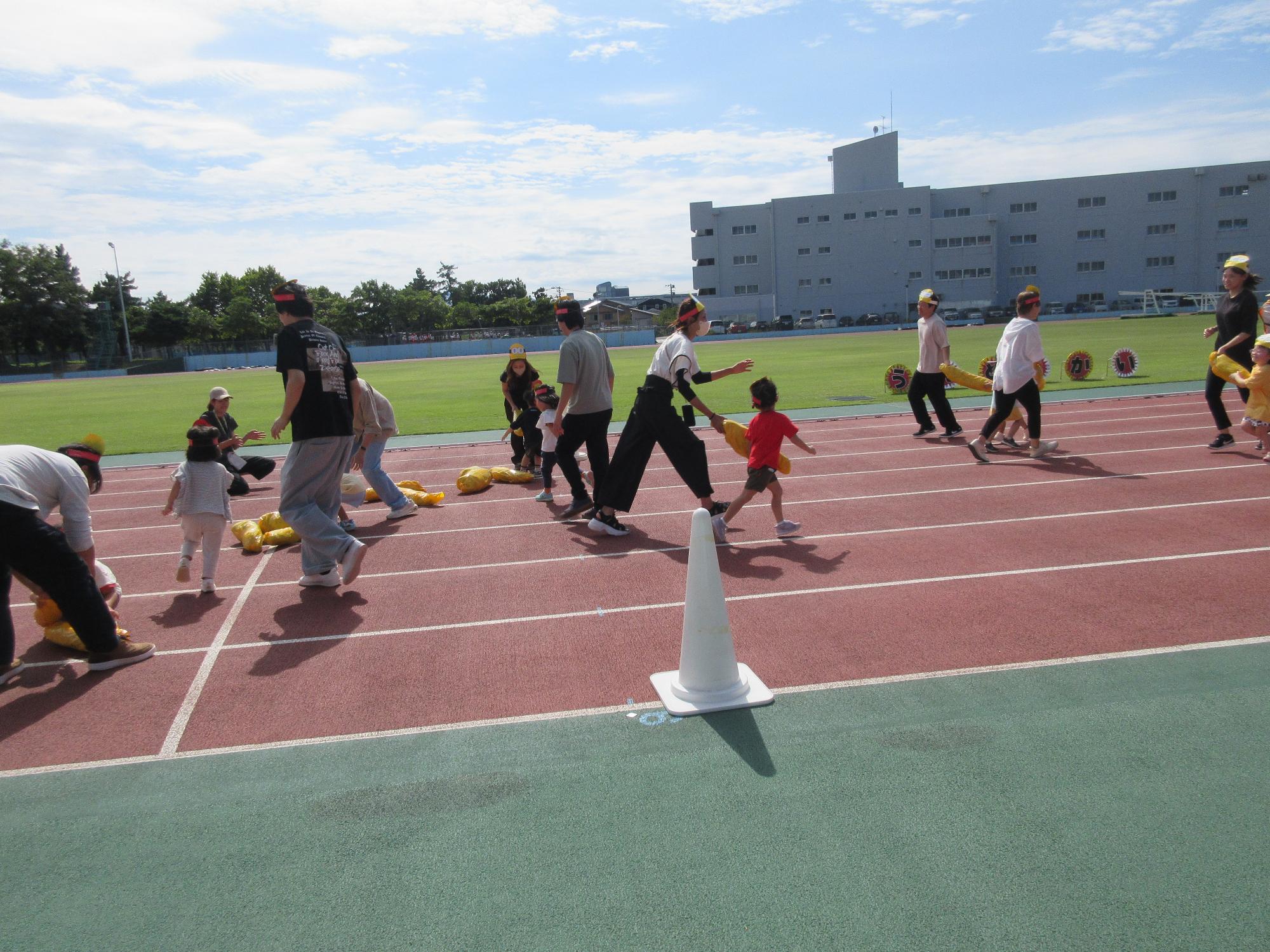 写真：親子で大きなバナナをゴールまで運んでいます