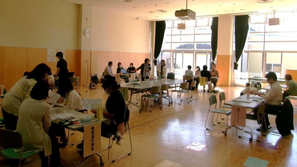 写真：広い会議室で企業ブースを設置しました。中央には休憩スペースがあります