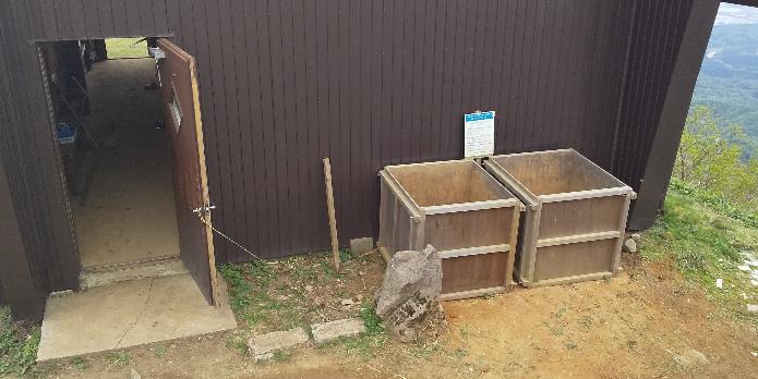 写真：山頂にある小屋の脇に置かれた2つの土置き場