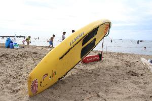 砂浜に立てかけられた黄色いレスキューボード。長さは約3メートルあります