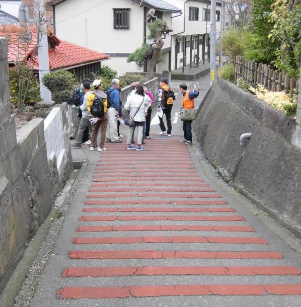 参加者が高低差を体感できる、なだらかな下り坂を歩いている写真