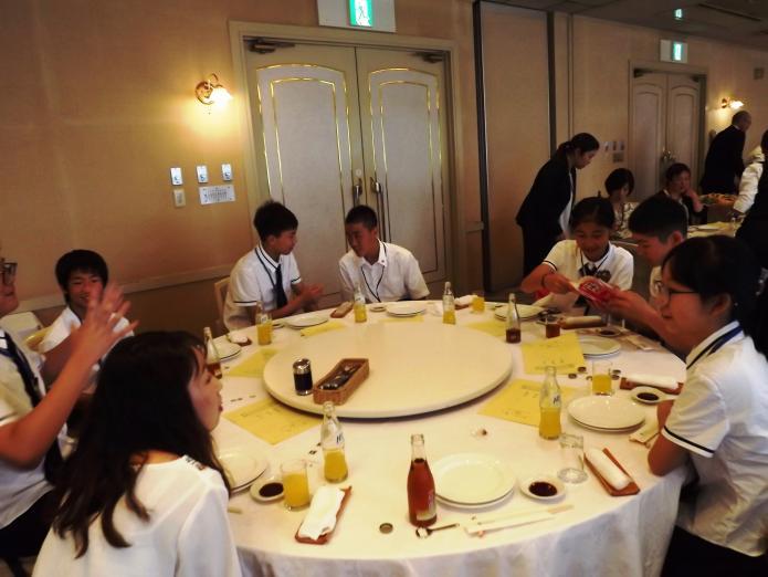 料理の並んだテーブルを囲み、両国の中学生が談笑しています