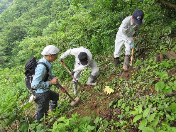 写真：八石山登山道の階段をスコップで土を盛り、補修している様子