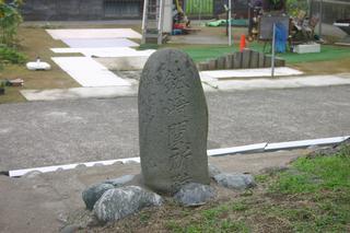 鉢崎関所跡看板の横にあるハッサキ関所跡と刻まれた丸みを帯びた石碑の写真