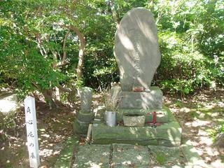 洞雲寺の敷地内にある台座の上に自然石を削った墓石が立てられている貞心尼の墓の写真