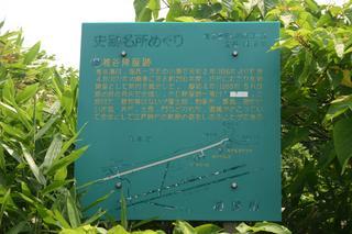 椎谷陣屋跡途中にある小高い緑の木々の中に立っている椎谷陣屋跡の説明文が書かれた案内看板の写真