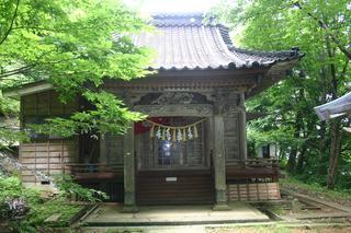 緑豊かな木々に囲まれた瓦屋根の胞姫（よなひめ）神社の写真