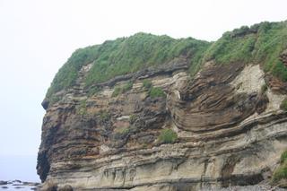 岩肌に湾曲した地層が表れてる牛ヶ首層内褶曲の写真