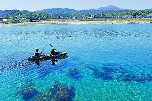 写真：青く透き通る海に浮かぶ二人乗りのカヤック