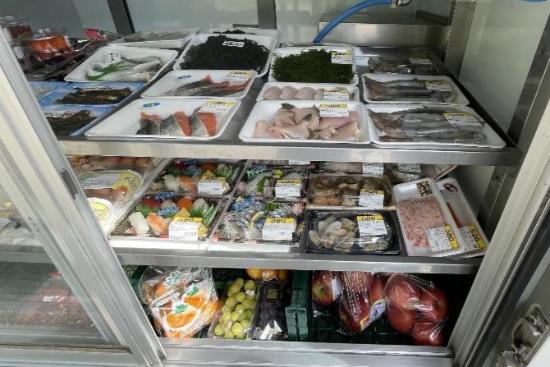 写真：日本海鮮魚センターの取り扱い商品。鮮魚や刺身、果物などが冷蔵室に並んでいます。s