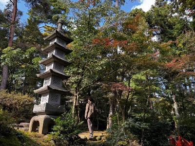 写真：11月7日の園内の様子。石灯籠と散策する観光客が写っています。周りの木々はまだ青葉です。