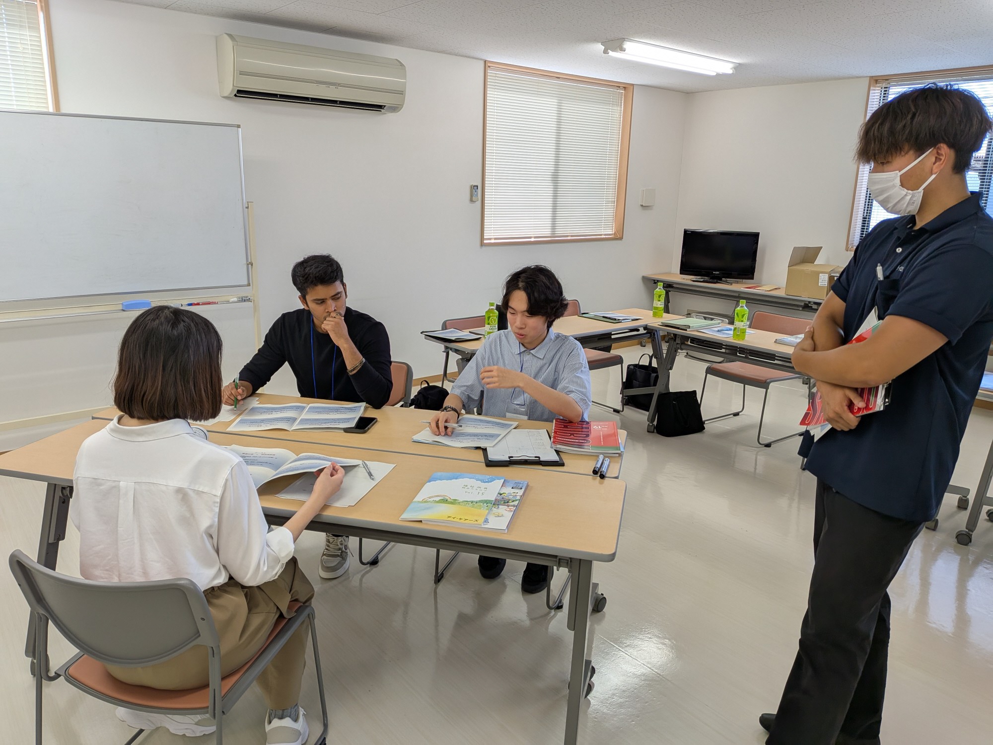 写真：「社長からの挑戦状」に挑む学生たち。3人の学生が意見を出し合っています