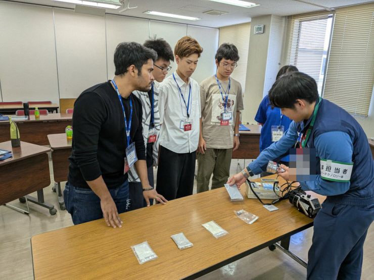 写真：東京パワーテクノロジー株式会社の社員から環境分析の方法を説明される学生たち