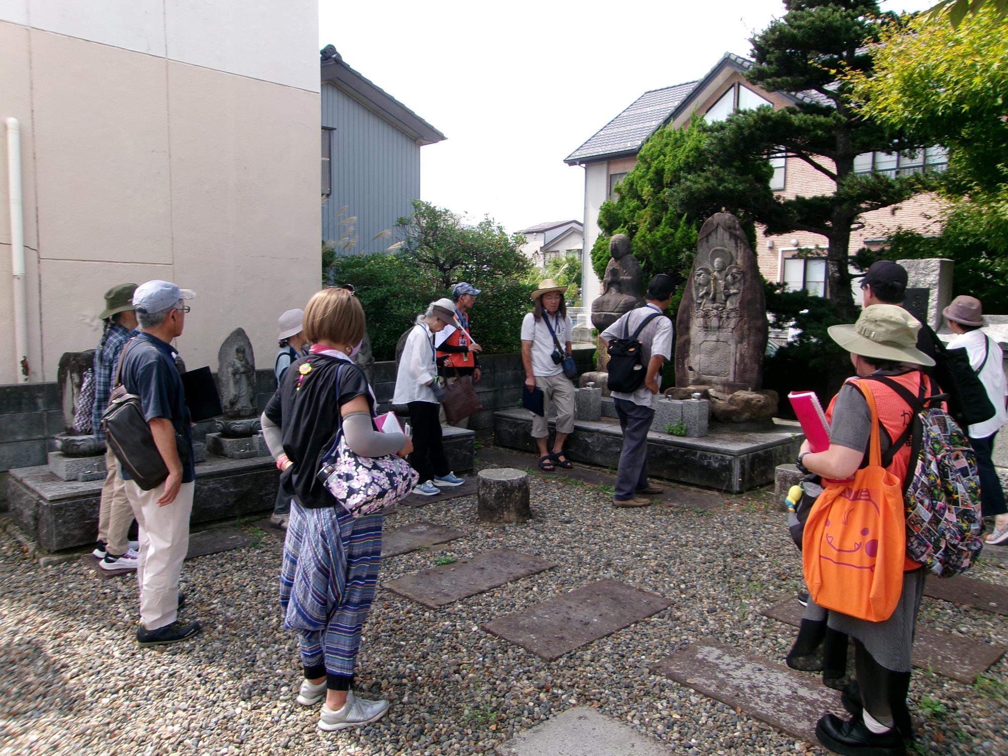写真：釈迦堂跡を説明するガイドとガイド体験の参加者