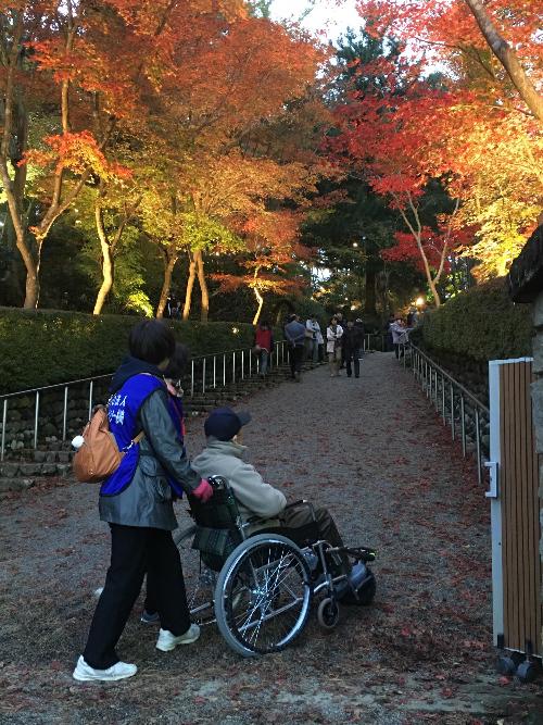 写真：旅サポーターが車椅子で紅葉見頃の松雲山荘内を案内する様子