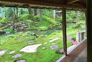 一面が苔に覆われ、踏み石や池庭石などが配置された庭園