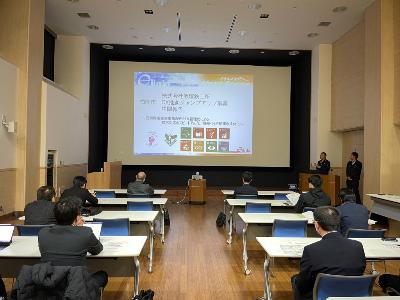 写真：前回の活動結果報告会の様子。プロジェクターを使って、企業担当者が説明をしています