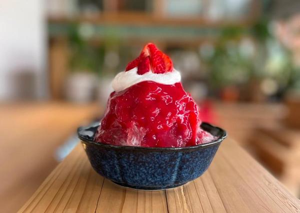 米と餡あやこやの越後姫かき氷です。かき氷にはいちごのシロップがたっぷりかけてあり、上にクリームといちごがのっています。