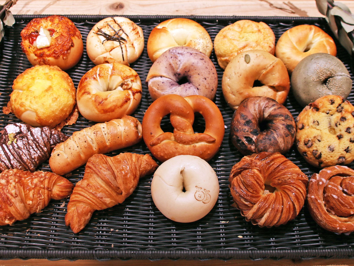 写真：かごの上にびわじまベーカリーのいろんな種類のパンが並べられています。