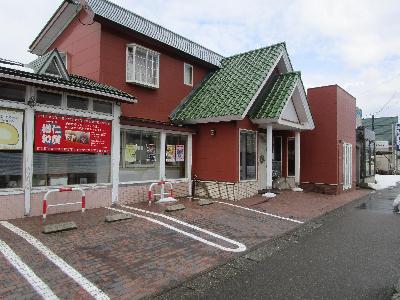 写真：茶色の壁と緑色の屋根が特徴の菓子工房やしろの外観