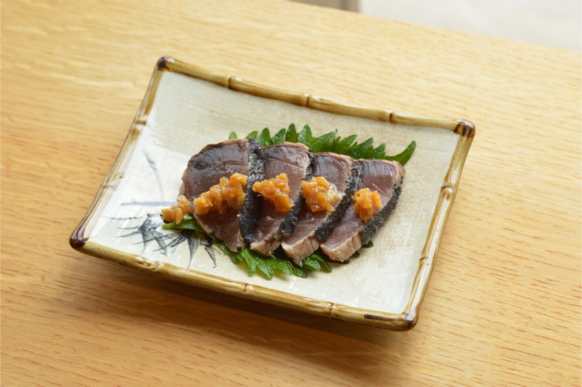 写真：レモン糀生姜みそ漬の使用例。カツオのたたきの上にレモン糀生姜みそ漬がトッピングされています