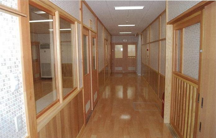 床材や窓枠にも木材を使用した廊下の写真