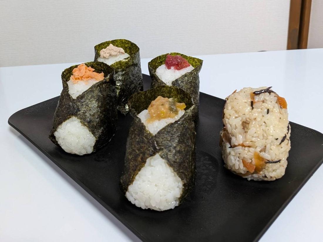 写真：おにぎりが5種類並んでいます。左からツナマヨ、シャケ、梅、ネギミソ、五目のおにぎりがあります。