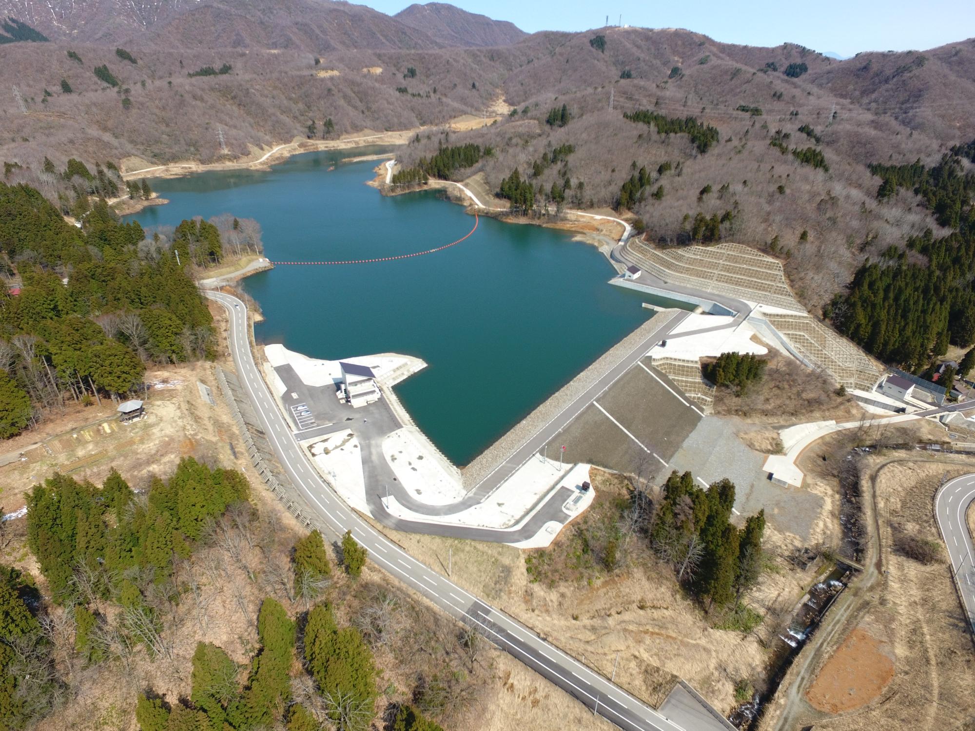三方を山に囲まれ、中央に水をたたえた市野新田ダムが写っています
