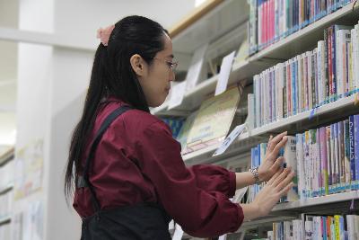 写真：図書を整理する田村さん